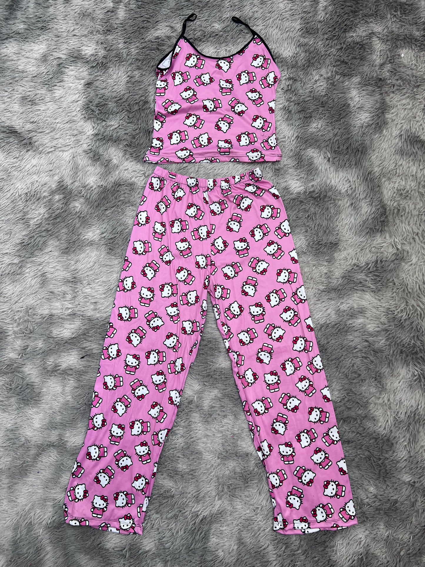 hello kitty saludando fondo rosa blusa con pantalón pijama de dama